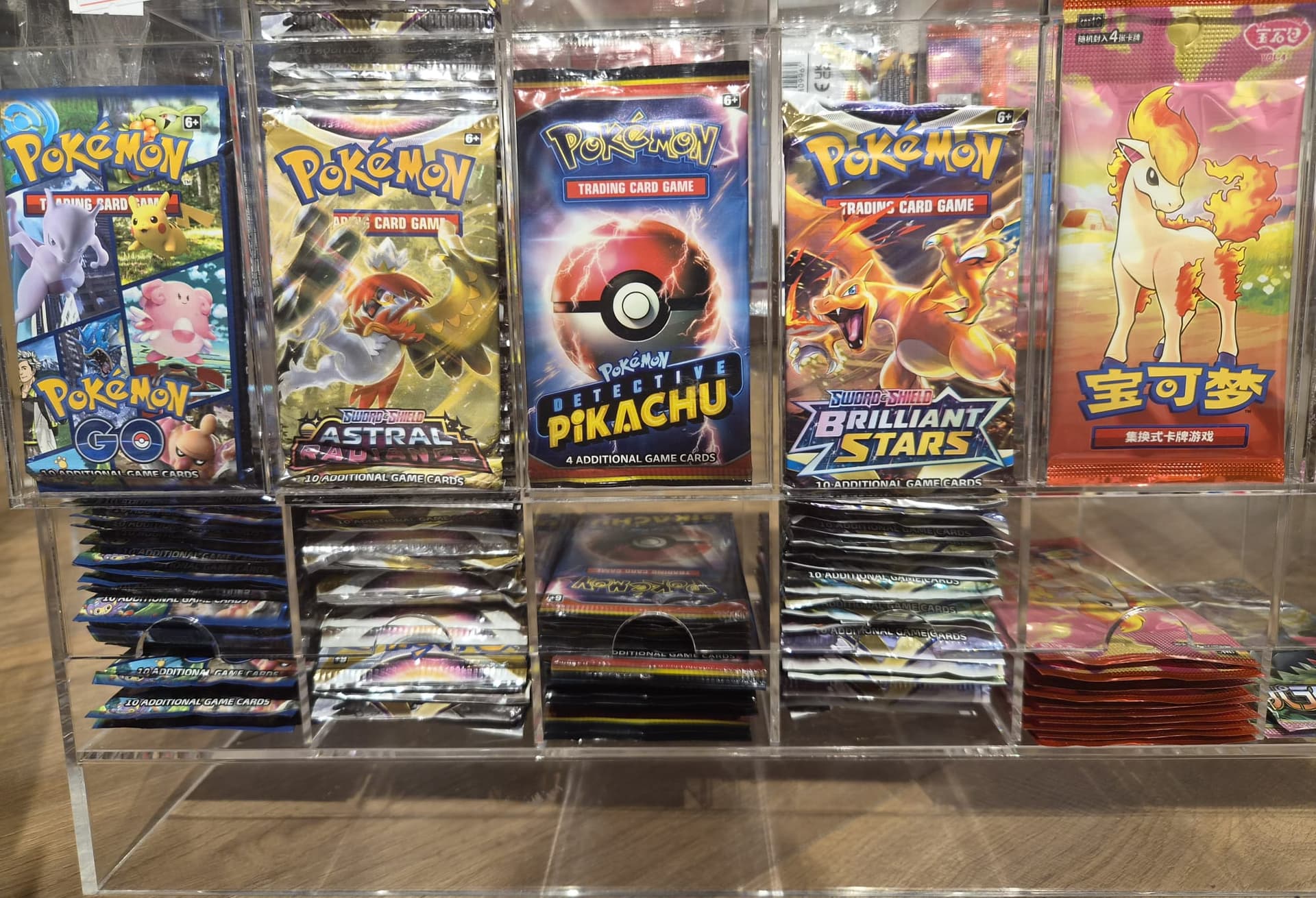 מדפי חנות Pokezone המציגים מגוון חבילות לוז פק של סטים שונים.
