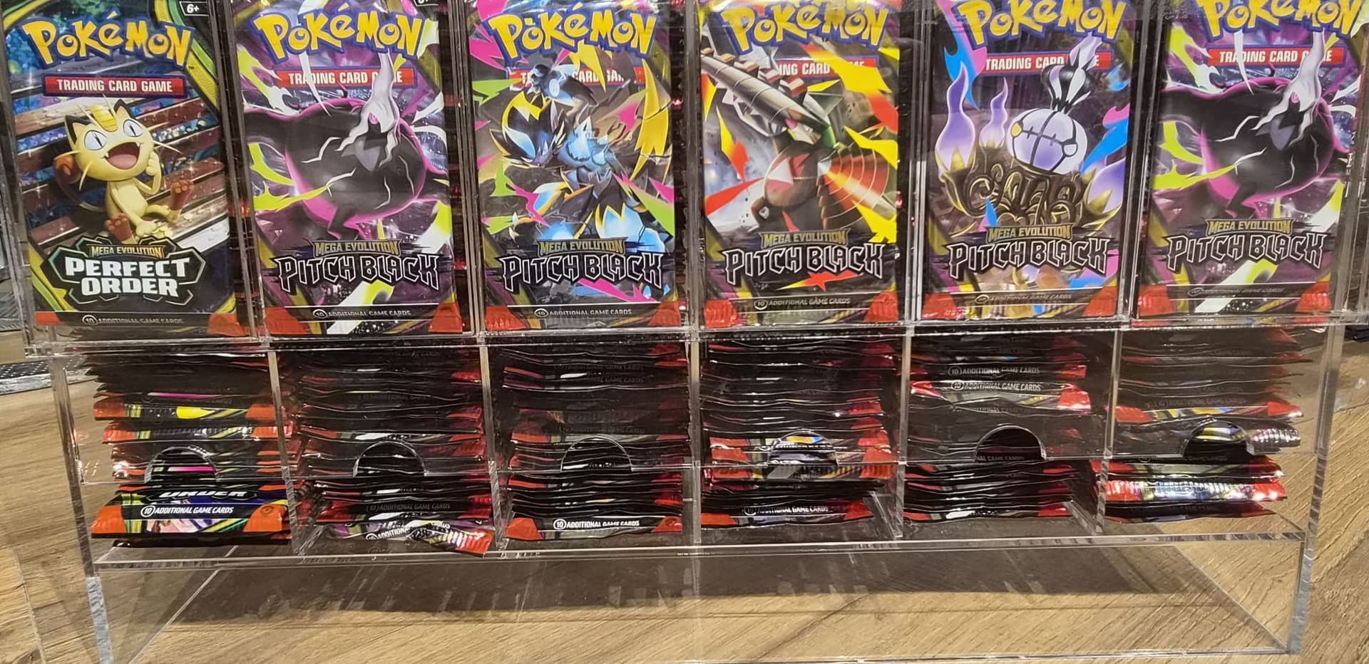 מדפי חנות Pokezone המציגים חבילות לוז פק של הסט pitch black.
