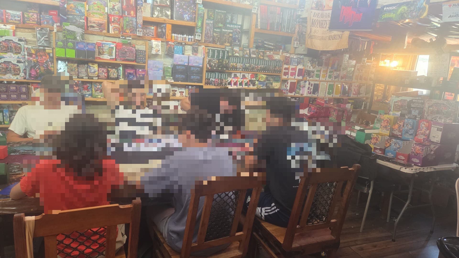 שחקנים בטורניר משחקי קלפים בסירולניה, מוקפים במבחר עצום של משחקי קלפים אספניים ומוצרים נלווים.