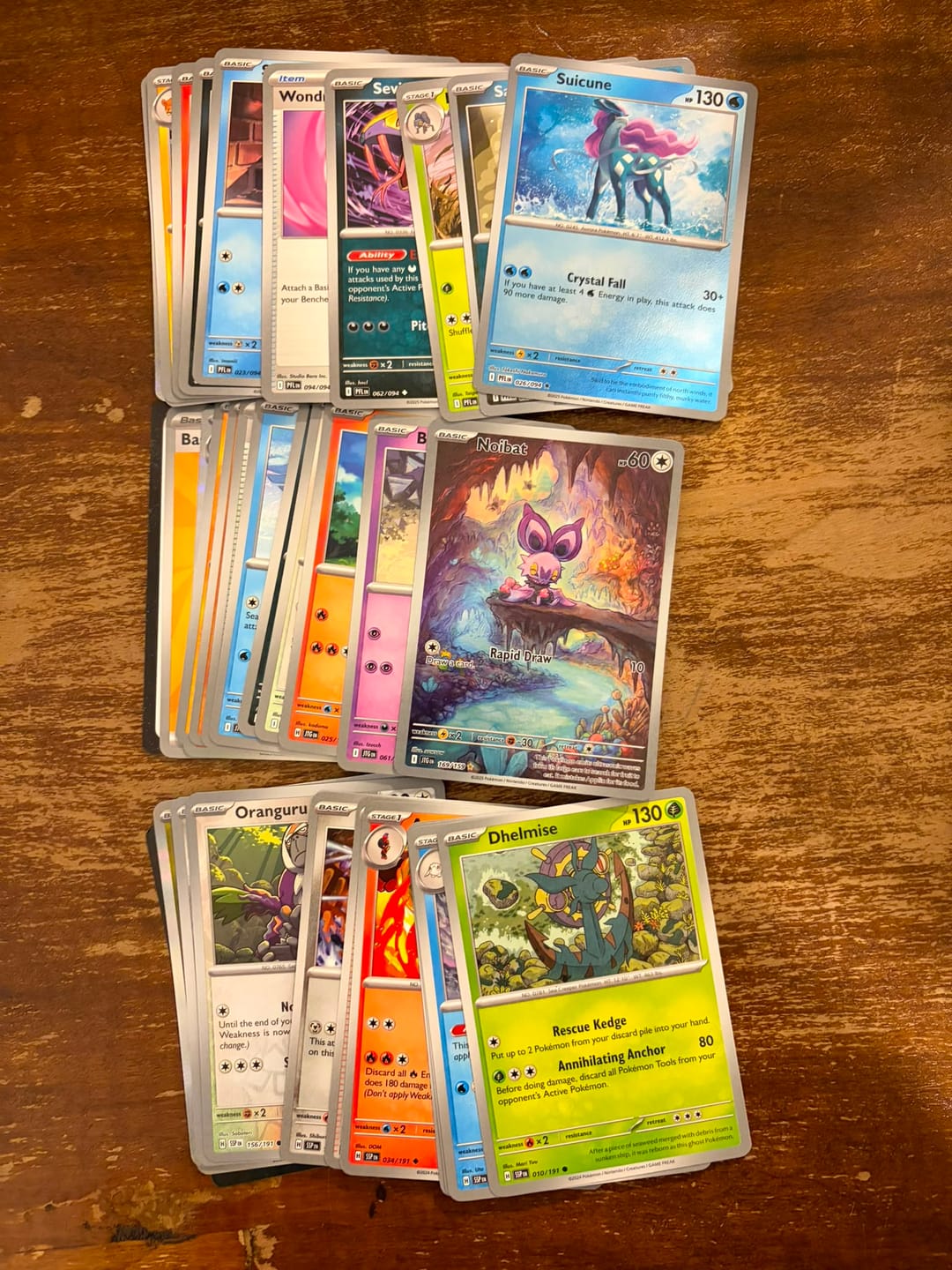 קלפי פוקימון מתוך פתיחת Ultra Ball Tin מסודרים בערימות, עם קלף ה־NAIBAT 169/159 כהיט היחיד והבולט מהפתיחה.